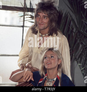 Rock- und der britische Pop-Sänger Rod Stewart posiert zusammen mit senneur damaligen Freundin, der schwedischen Schauspielerin Britt Ekland für einige Fotos, 1970er. La chanteuse pop et rock anglais Rod Stewart pose pour quelques photos avec sa petite amie, l'actrice suédoise Britt Ekland, 1970. Banque D'Images