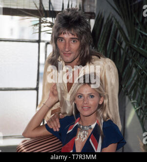 Rock- und der britische Pop-Sänger Rod Stewart posiert zusammen mit senneur damaligen Freundin, der schwedischen Schauspielerin Britt Ekland für einige Fotos, 1970er. La chanteuse pop et rock anglais Rod Stewart pose pour quelques photos avec sa petite amie, l'actrice suédoise Britt Ekland, 1970. Banque D'Images