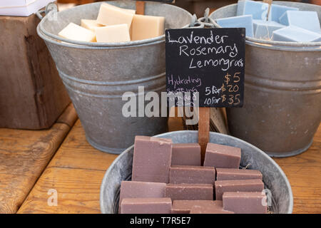 A la photo en gros de barres de savon fait maison colorée dans de grands seaux en métal à vendre à un marché de producteurs Banque D'Images