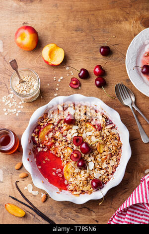 Crumble de pêches et de cerises dans un plat allant au four. Vue d'en haut. Copier l'espace. Banque D'Images