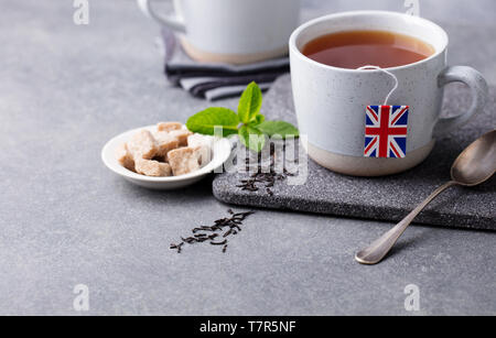 Le thé dans les tasses avec drapeau britannique plateau étiquette de sac. Fond gris. Copier l'espace. Banque D'Images