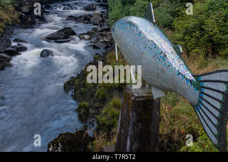 Le bouillonnement Ketchikan Creek est passé d'une sculpture d'un saumon près de la célèbre rue du Ruisseau à Ketchikan Banque D'Images