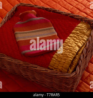 Bouteille d'eau chaude avec couverture en tricot sur bord satin quilt Banque D'Images