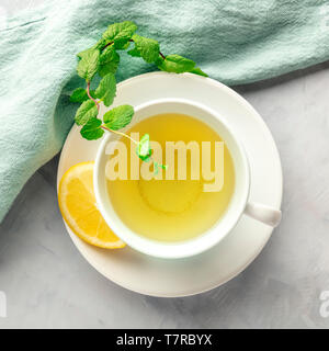 Une tasse de thé vert avec du citron et des feuilles de menthe, tourné par le haut Banque D'Images