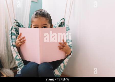 Sweet little girl dans sa chambre près de la fenêtre, drôle belle enfant s'amusant dans la chambre des enfants, l'espace de copie pour le texte Banque D'Images