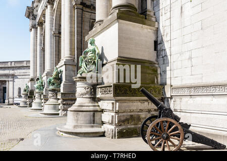 Vue rapprochée des statues à la base des colonnes sur le côté est de l'arcade du Cinquantenaire, l'Arc de triomphe à Bruxelles, Belgique. Banque D'Images