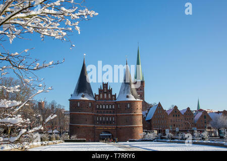 La porte de ville gothique brique/ Porte de Holstein Holstein dans la ville hanséatique de Lübeck en hiver, Schleswig-Holstein, Allemagne Banque D'Images