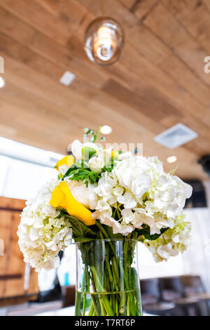 Libre vue verticale d'arrangement de fleurs bouquet de fleurs de mariage sur la table de réception dîner au restaurant avec salle de restaurant rustique plafond Banque D'Images