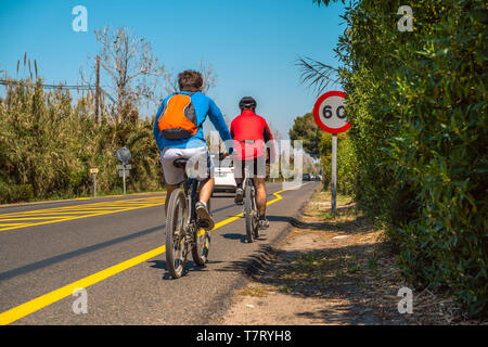 Valencia, Espagne ; 13 avril, 2019 : Les cyclistes sur la route et signe de limitation de vitesse. 60 km/h la limitation de vitesse. L'autoroute la sécurité à vélo. Banque D'Images