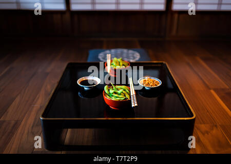 Maison machiya japonais traditionnel ryokan ou restaurant avec table en bois laqué noir avec des aliments à base de haricots et la sauce soya Natto Banque D'Images