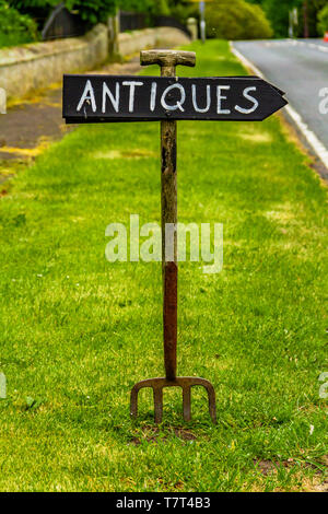 Inscrivez-vous à la main fait d'un vieux jardin publicité fourche une boutique d'antiquités dans Ford village, Northumberland, Angleterre. Mai 2018. Banque D'Images