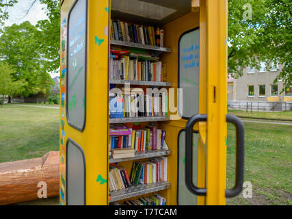 Brieskow Finkenheerd, Allemagne. 06 mai, 2019. La porte d'un jaune, ancienne cabine téléphonique est ouvert. À l'intérieur il y a des étagères avec des livres sur eux. Ici vous pouvez mettre dans les livres de donner et prendre avec vous sans frais. Crédit : Patrick Pleul/dpa-Zentralbild/ZB/dpa/Alamy Live News Banque D'Images