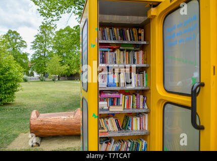 Brieskow Finkenheerd, Allemagne. 06 mai, 2019. La porte d'un jaune, ancienne cabine téléphonique est ouvert. À l'intérieur il y a des étagères avec des livres sur eux. Ici vous pouvez mettre dans les livres de donner et prendre avec vous sans frais. Crédit : Patrick Pleul/dpa-Zentralbild/ZB/dpa/Alamy Live News Banque D'Images