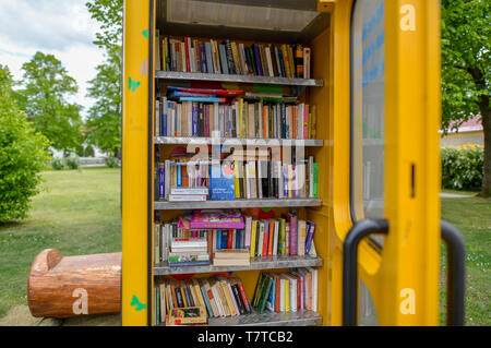 Brieskow Finkenheerd, Allemagne. 06 mai, 2019. La porte d'un jaune, ancienne cabine téléphonique est ouvert. À l'intérieur il y a des étagères avec des livres sur eux. Ici vous pouvez mettre dans les livres de donner et prendre avec vous sans frais. Crédit : Patrick Pleul/dpa-Zentralbild/ZB/dpa/Alamy Live News Banque D'Images