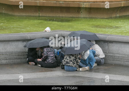 Londres, Royaume-Uni. 9 mai, 2019. Les piétons et les touristes se blottissent sous les parasols à Trafalgar Square lors de fortes averses après un brillant début de la journée à Londres : Crédit amer ghazzal/Alamy Live News Banque D'Images