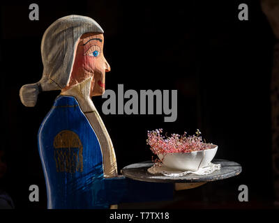 En bois sculpté un waiter holding un bac avec une fleur afficher à l'extérieur d'un restaurant à Syracuse, en Sicile. Banque D'Images