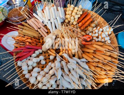 Divers brochettes avec des saucisses et de la viande, des boulettes de viande, en panier de bambou dans un marché, la cuisine thaïlandaise, Thaïlande Banque D'Images