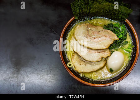 Un petit bol de Ramen au porc, algues, papier et un œuf dur est assis sur une table à Yokosuka, Japon. Banque D'Images