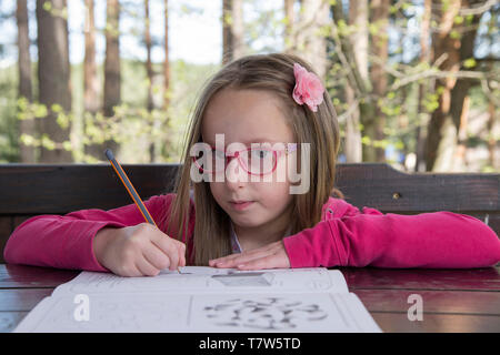 Belle fille faire ses devoirs dans la nature Banque D'Images