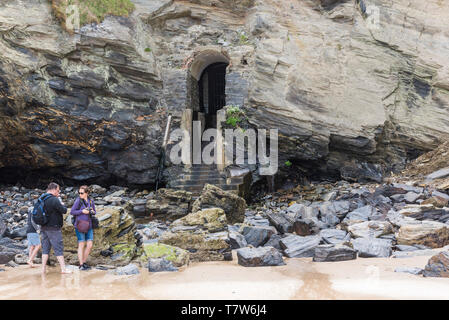 Les vacanciers à la découverte des rochers autour de l'historique entrée du tunnel désaffecté menant de Great Western Beach au club Victoria en Newqua Banque D'Images