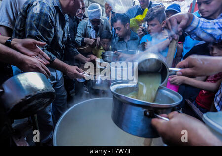 Palestiniens vu se préparer la nourriture distribuée dans quartier Shajaiya durant le Ramadan. Troisième jour du Ramadan. Les musulmans du monde participent dans le saint mois de jeûne du Ramadan, le mois le plus saint dans le calendrier islamique, s'abstenir de manger, boire et fumer de l'aube au crépuscule. Banque D'Images