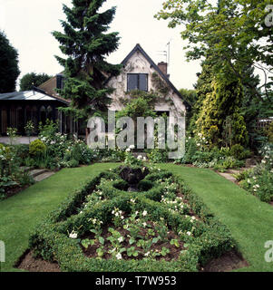 À côté de conifères Hautes maison avec petit nœud dans le jardin pelouse Banque D'Images