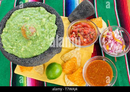 Table de style mexicain de fête avec du guacamole et de la variété de sauces chaudes sur couverture dynamique Banque D'Images