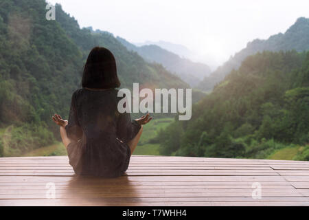 Young woman doing yoga au coucher du soleil Banque D'Images
