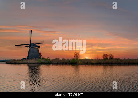 Une longue exposition du Kinderdjik moulin lever du soleil la réflexion sur l'eau calme de la canal Alblasserdam Banque D'Images