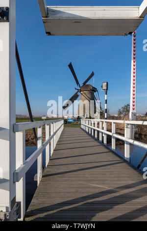 Ciel bleu avec le paysage hollandais moulin sur le pont blanc au-dessus d'une eau claire et calme à l'aube, Pays-Bas Banque D'Images