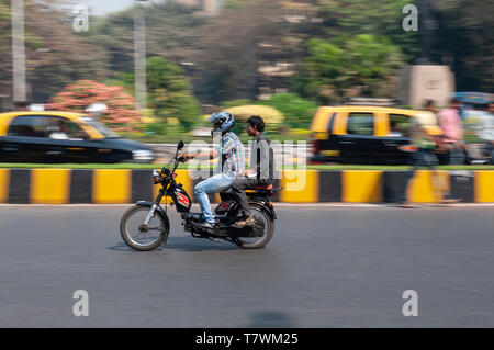 Wo men riding moped sur une voie publique de la ville de Mumbai Banque D'Images