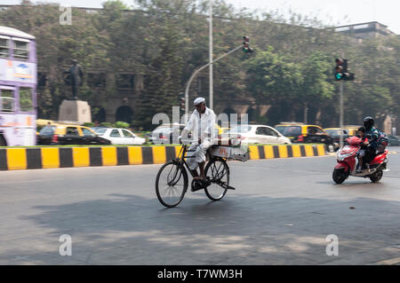 Plus indien à vélo sur une voie publique de la ville de Mumbai avec shopping sur l'arrière de son vélo Banque D'Images