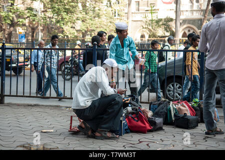 Wallahs Tiffin lunch box ou préparer leurs sacs hommes près de la gare la Gare Chhatrapati Shivaji de Mumbai, Inde Banque D'Images