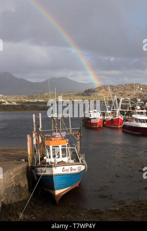 L'Irlande, dans le comté de Galway, Ballynakill, Connemara, des bateaux en bois et les bateaux de pêche dans le port, les montagnes Twelve Bens et Tully montagnes en arrière-plan Banque D'Images