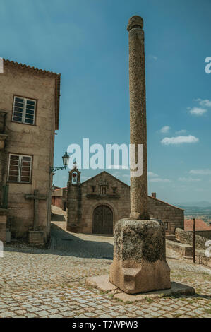 Pilori en pierre sur une petite place déserte en face de vieille église avec Bell sur le toit de Monsanto. Un mignon et curieux village historique du Portugal. Banque D'Images