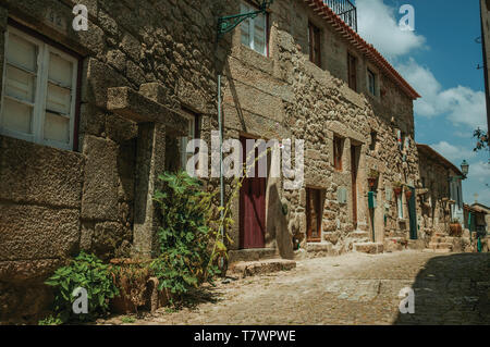 Charmante façade de maisons anciennes aux murs faits de pierre et les portes en bois sur l'allée déserte de Monsanto. Un mignon et curieux village historique du Portugal. Banque D'Images