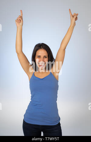 Portrait de jeune femme séduisante des succès à célébrer la victoire ou feeling lucky et joyeuse danse et faisant des gestes avec les bras isolé célébration Banque D'Images