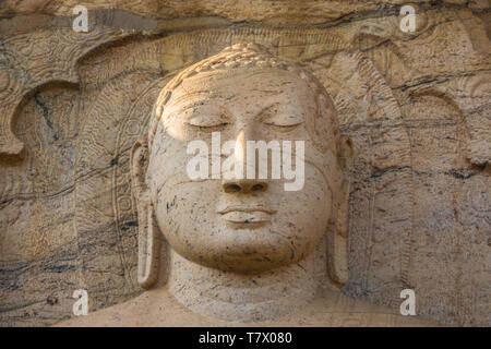 Détail de la tête de la Bouddha assis, l'un des trois, taillée dans le socle granitique au Gal Vihara de culte à Polonnaruwa, Sri Lanka. Banque D'Images