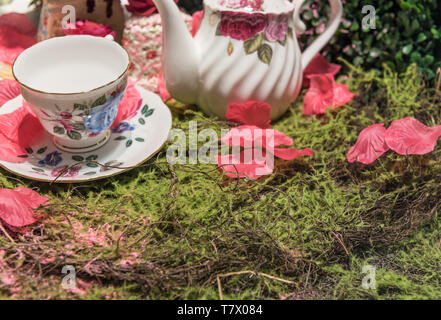 Thé Crème Scène Parti de pique-nique avec pétales de fleurs et de thé en porcelaine ancienne Banque D'Images