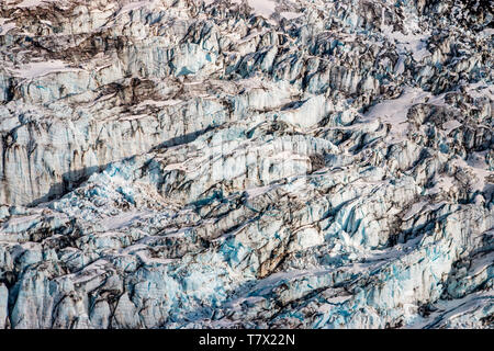 La Knik Glacier en Alaska. Manque de neige exposer les cendres retombées de la redoute à proximité de volcan, la réduction de l'effet albédo. Il y a des milliers de glaciers en Alaska, et au moins 616 d'entre eux sont nommés. Ensemble, ils sont en train de perdre 75 milliards de tonnes de glace chaque année en raison de la fonte. Ce chiffre est susceptible d'augmenter dans les années à venir. Mai 2015 a été la plus chaude en 91 ans. La couleur bleue est naturellement produit, mais est renforcé par underexposing l'image. Banque D'Images