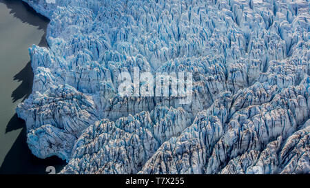 La Knik Glacier en Alaska. Manque de neige exposer les cendres retombées de la redoute à proximité de volcan, la réduction de l'effet albédo. Il y a des milliers de glaciers en Alaska, et au moins 616 d'entre eux sont nommés. Ensemble, ils sont en train de perdre 75 milliards de tonnes de glace chaque année en raison de la fonte. Ce chiffre est susceptible d'augmenter dans les années à venir. Mai 2015 a été la plus chaude en 91 ans. La couleur bleue est naturellement produit, mais est renforcé par underexposing l'image. Banque D'Images