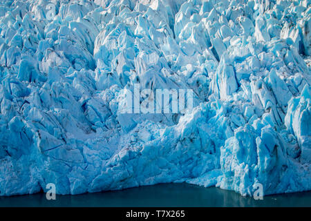 La Knik Glacier en Alaska. Manque de neige exposer les cendres retombées de la redoute à proximité de volcan, la réduction de l'effet albédo. Il y a des milliers de glaciers en Alaska, et au moins 616 d'entre eux sont nommés. Ensemble, ils sont en train de perdre 75 milliards de tonnes de glace chaque année en raison de la fonte. Ce chiffre est susceptible d'augmenter dans les années à venir. Mai 2015 a été la plus chaude en 91 ans. La couleur bleue est naturellement produit, mais est renforcé par underexposing l'image. Banque D'Images