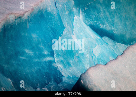 La Knik Glacier en Alaska. Manque de neige exposer les cendres retombées de la redoute à proximité de volcan, la réduction de l'effet albédo. Il y a des milliers de glaciers en Alaska, et au moins 616 d'entre eux sont nommés. Ensemble, ils sont en train de perdre 75 milliards de tonnes de glace chaque année en raison de la fonte. Ce chiffre est susceptible d'augmenter dans les années à venir. Mai 2015 a été la plus chaude en 91 ans. La couleur bleue est naturellement produit, mais est renforcé par underexposing l'image. Banque D'Images