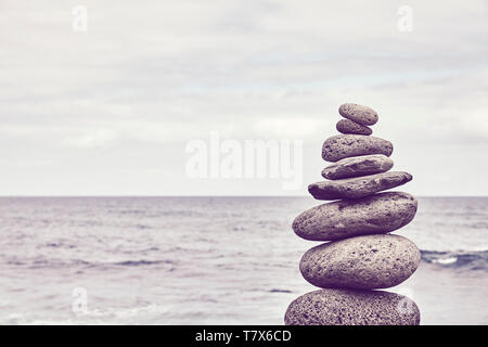 Pyramide fait de pierres sur une plage, dans des tons de couleur photo. Banque D'Images