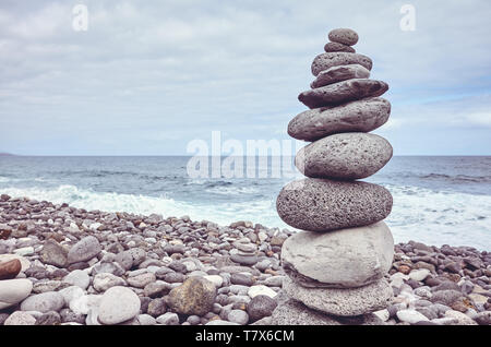 Pyramide fait de pierres sur une plage, dans des tons de couleur photo. Banque D'Images