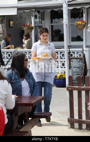 Lyme Regis, dans le Dorset - une serveuse qui sert du poisson et des frites à la clientèle à l'extérieur en plein air, 2019 Banque D'Images