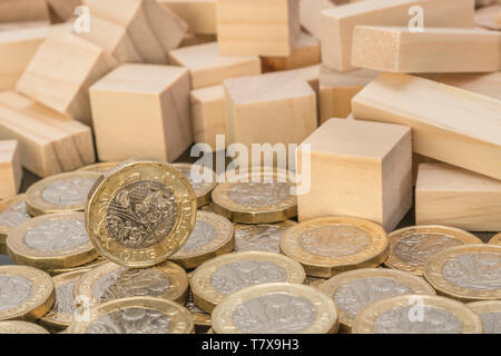 Pièces de monnaie neuves + briques et blocs de bois jumpés/tumeux. Krach de la livre sterling, effondrement des taux d'intérêt de liquidation de la livre sterling, krach du marché, effondrement des banques Banque D'Images