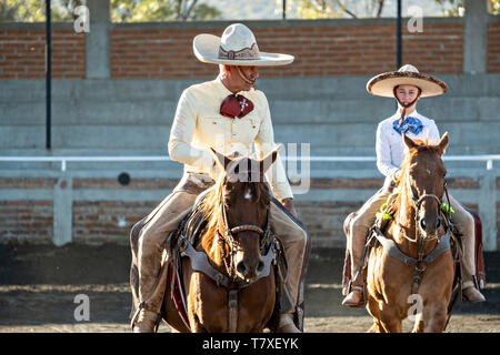 Juan Franco, Jr. et son père Juan Franco, soeur à cheval au niveau de la famille dans la session pratique Charreria Jalisco Highlands ville de Capilla de Guadalupe, au Mexique. La famille Franco mexicain a dominé pendant 40 ans de rodéo et a remporté trois championnats nationaux, cinq deuxièmes places et 5 troisièmes places. Banque D'Images