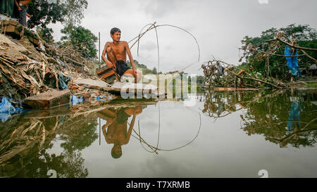 Mohammad Khokon à côté de ce qui était autrefois la maison de sa famille. Une crue éclair l'a emporté dans la rivière Jamuna à Sirajganj, au Bangladesh, en 2007. Le réchauffement climatique provoque la pluie de mousson et les inondations à commencer plus tôt. Le réchauffement climatique accentue également la fonte de la glace et de la neige dans l’Himalaya, qui alimente les rivières déjà saturées qui composent le delta du Gange. Le résultat est dévastateur pour les personnes qui vivent dans la région densément peuplée du delta. Alors que l'Himalaya et les inondations font des ravages depuis le nord, l'élévation du niveau de la mer provoque une intrusion d'eau salée dans les zones agricoles basses le long de th Banque D'Images