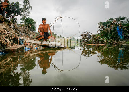 Mohammad Khokon à côté de ce qui était autrefois la maison de sa famille. Une crue éclair l'a emporté dans la rivière Jamuna à Sirajganj, au Bangladesh, en 2007. Le réchauffement climatique provoque la pluie de mousson et les inondations à commencer plus tôt. Le réchauffement climatique accentue également la fonte de la glace et de la neige dans l’Himalaya, qui alimente les rivières déjà saturées qui composent le delta du Gange. Le résultat est dévastateur pour les personnes qui vivent dans la région densément peuplée du delta. Alors que l'Himalaya et les inondations font des ravages depuis le nord, l'élévation du niveau de la mer provoque une intrusion d'eau salée dans les zones agricoles basses le long de th Banque D'Images